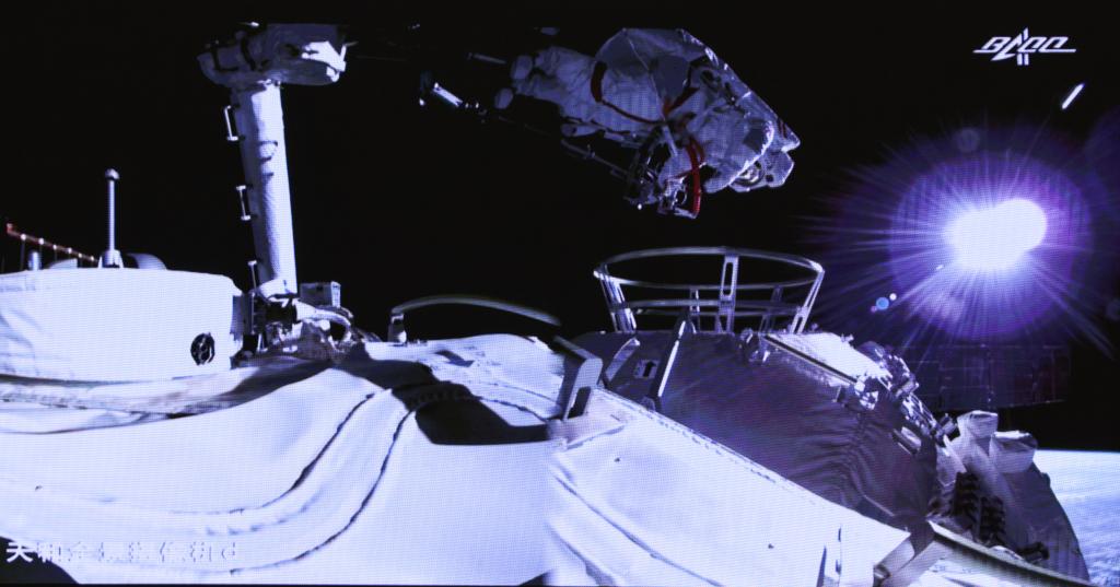 Космонавт на манипуляторе во время выхода 4 июля 2021 г.